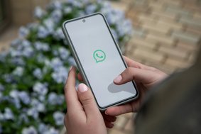 Smartphone mit dem Whatsapp-Logo auf weißem Grund