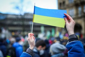 Person hält eine Ukraineflagge hoch